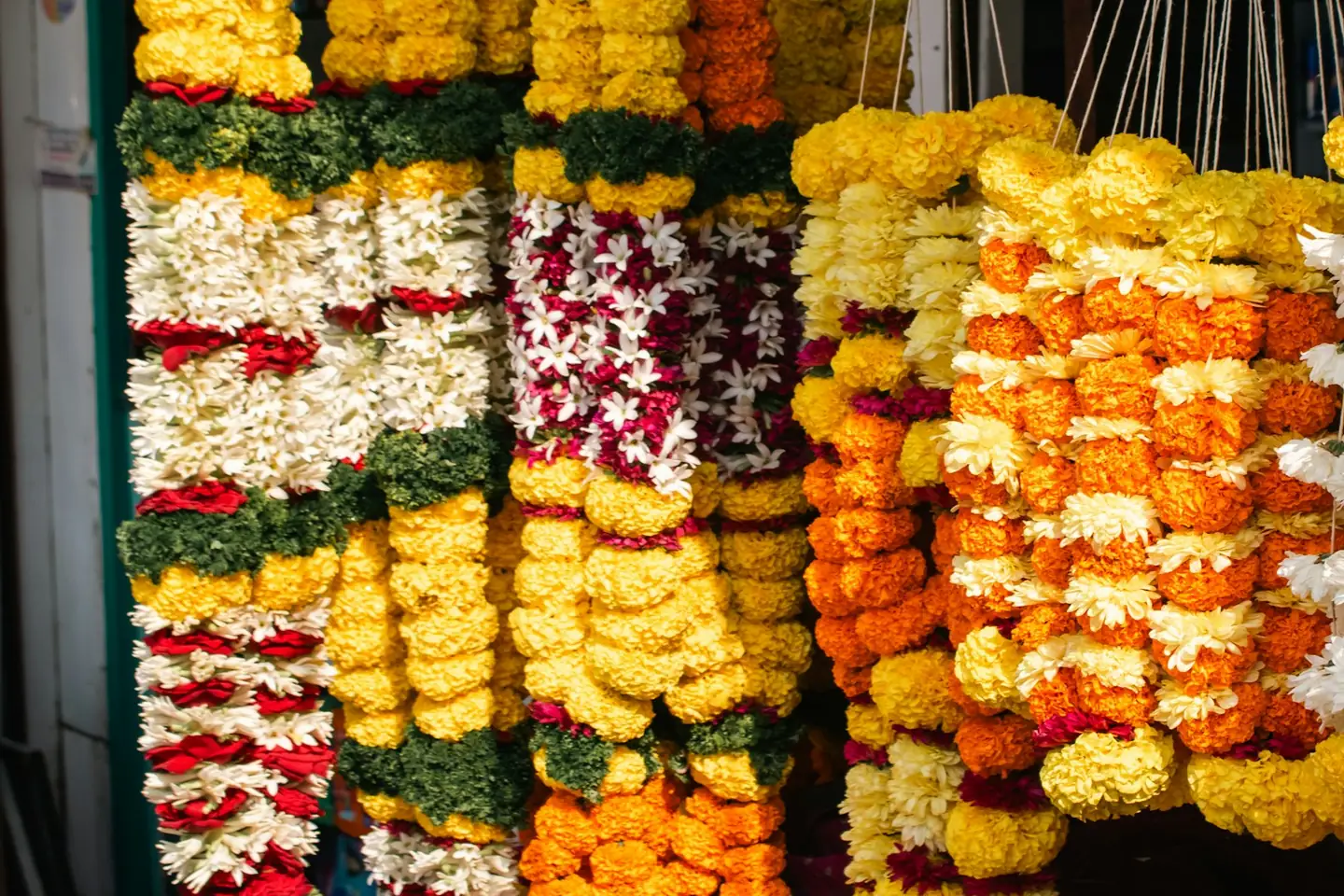 Roadside stall in Kamshet, Maharashtra, hung with marigold, jasmine and chrysanthemum garlands for sale
