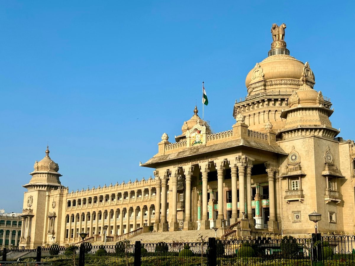 Vidhana Soudha, the Karnataka state legislature building in Bengaluru, in warm sunlight under a blue sky
