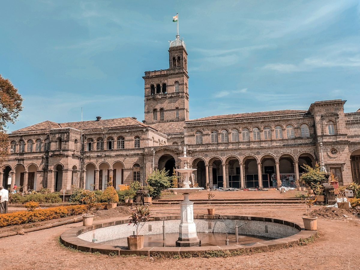 Main building of Savitribai Phule Pune University with its central tower and fountain garden, Pune